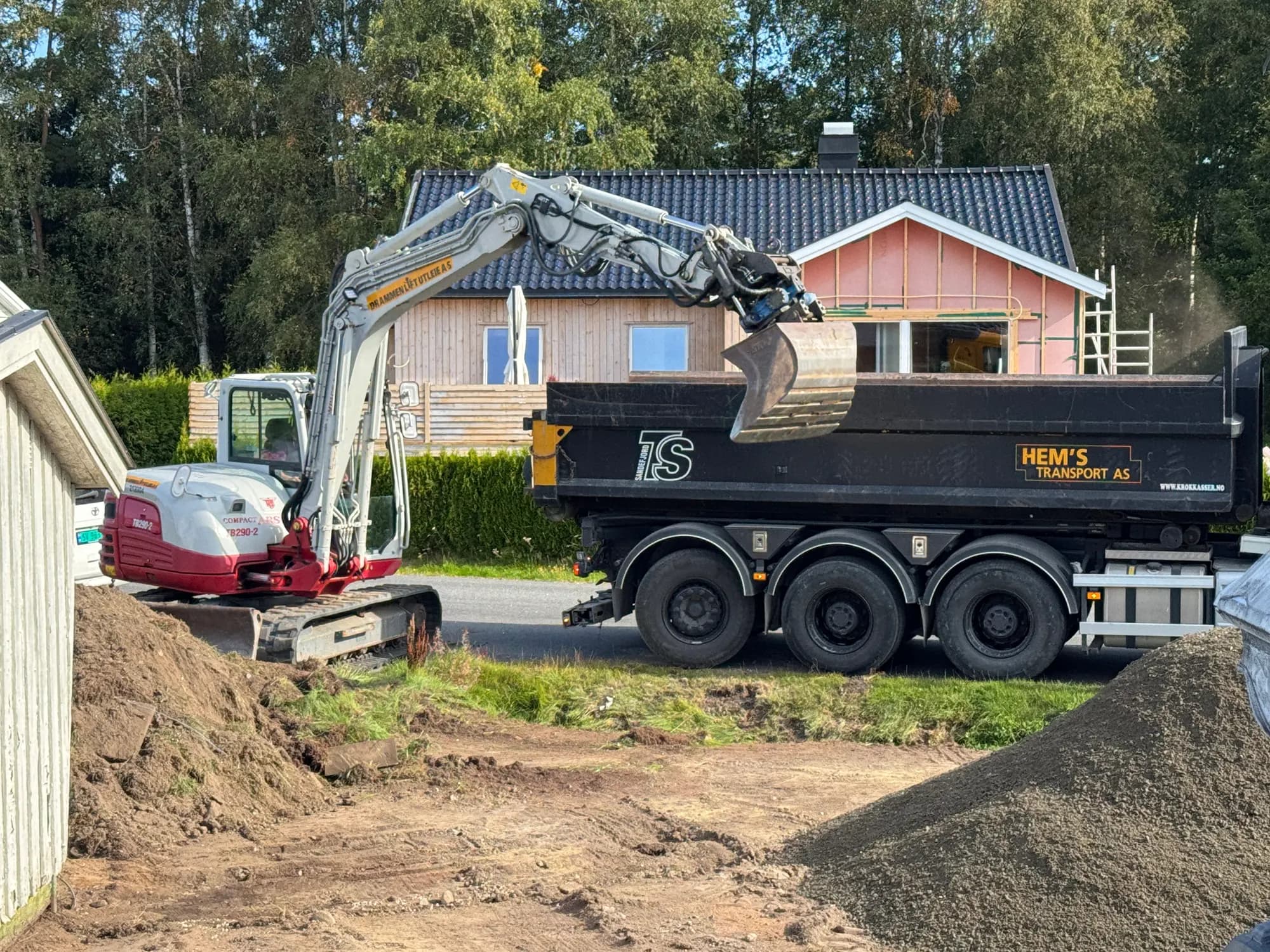 Gravemaskin laster masser over på lastebil