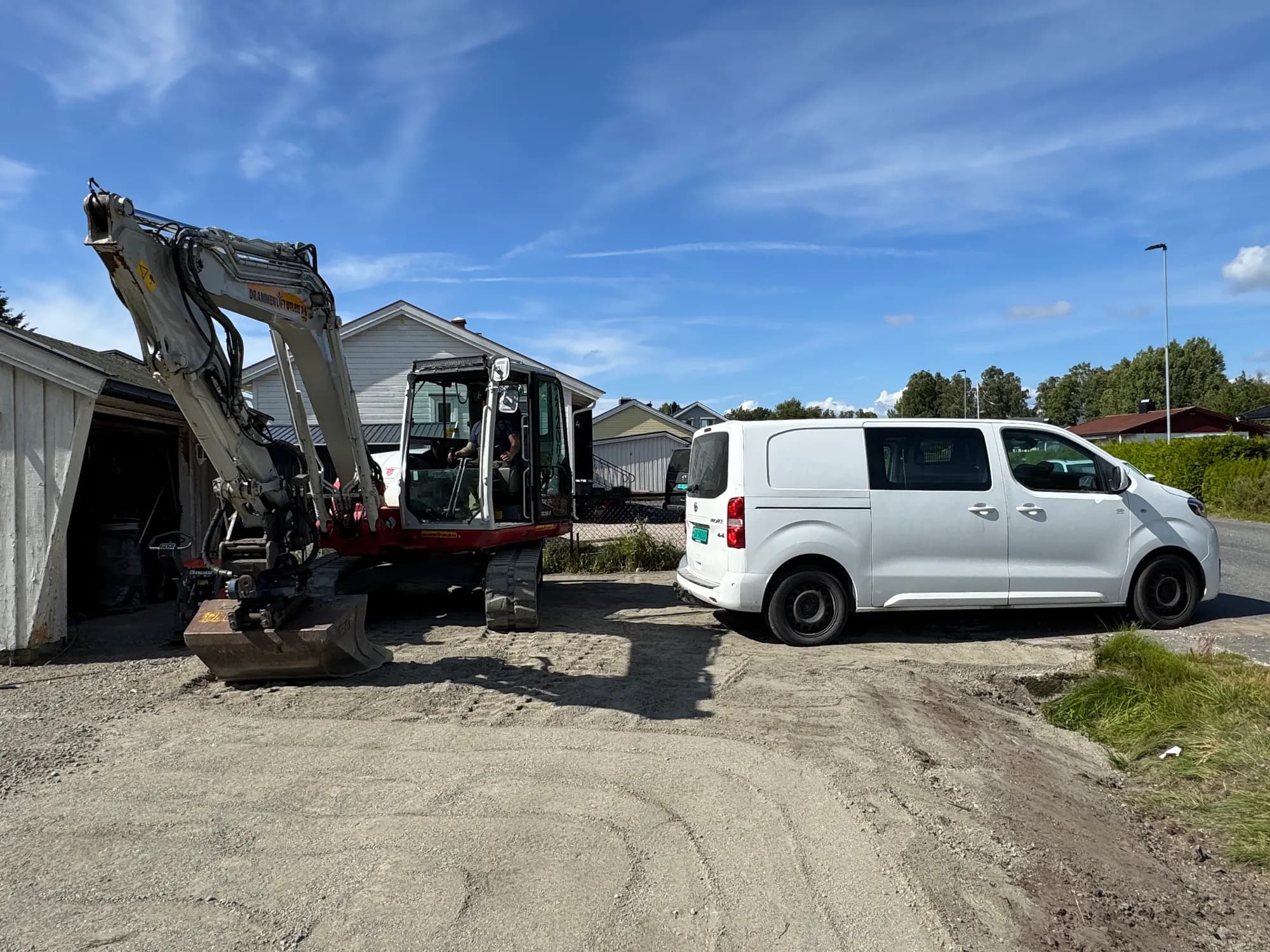 Gravemaskin og servicebil oppstilt på anlegget
